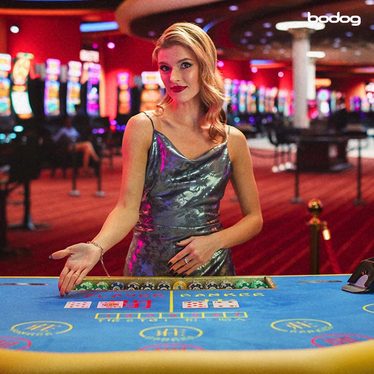 Dealer elegante de Baccarat em um cassino apontando para a mesa do jogo