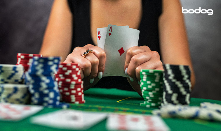 Jugadora de poker sosteniendo una pareja de ases