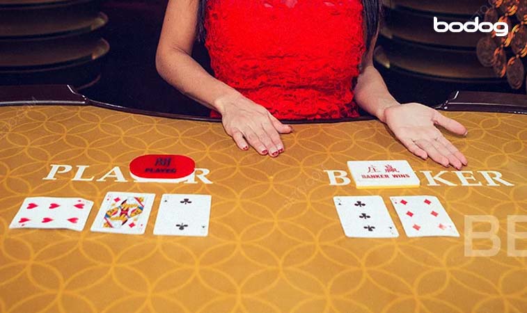 Mesa de baccarat con cartas y crupier