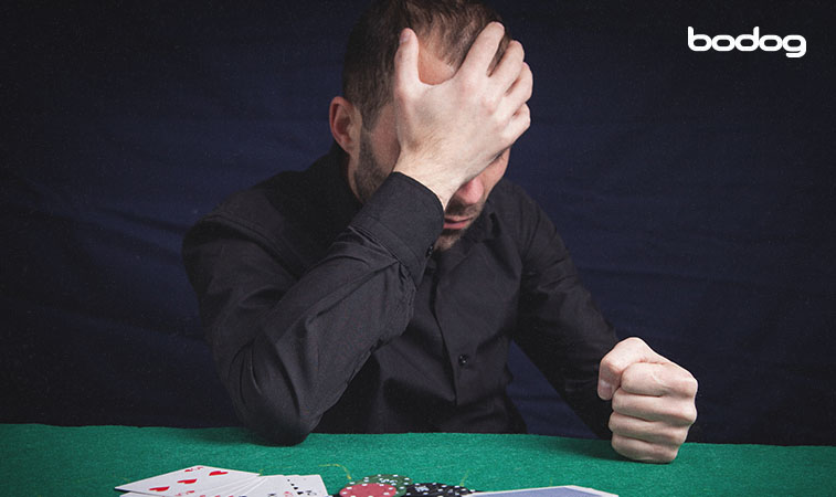 hombre con postura de enojo en una mesa de poker