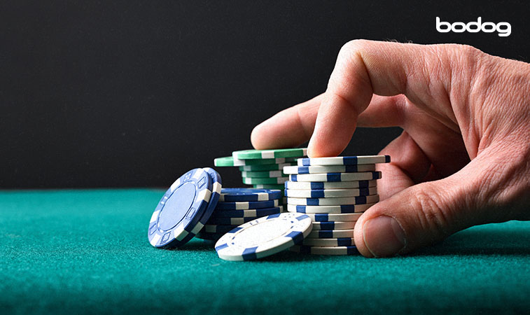 Mão sobre monte de fichas de poker