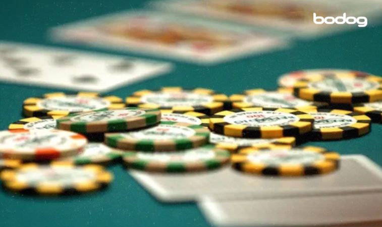 Baralho virado para baixo e fichas de poker sobre a mesa