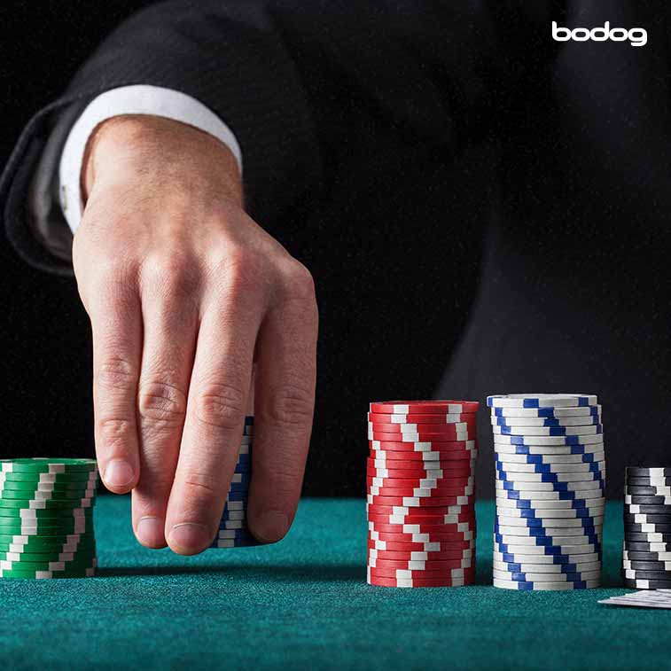 Mão masculina segurando fichas de cassino