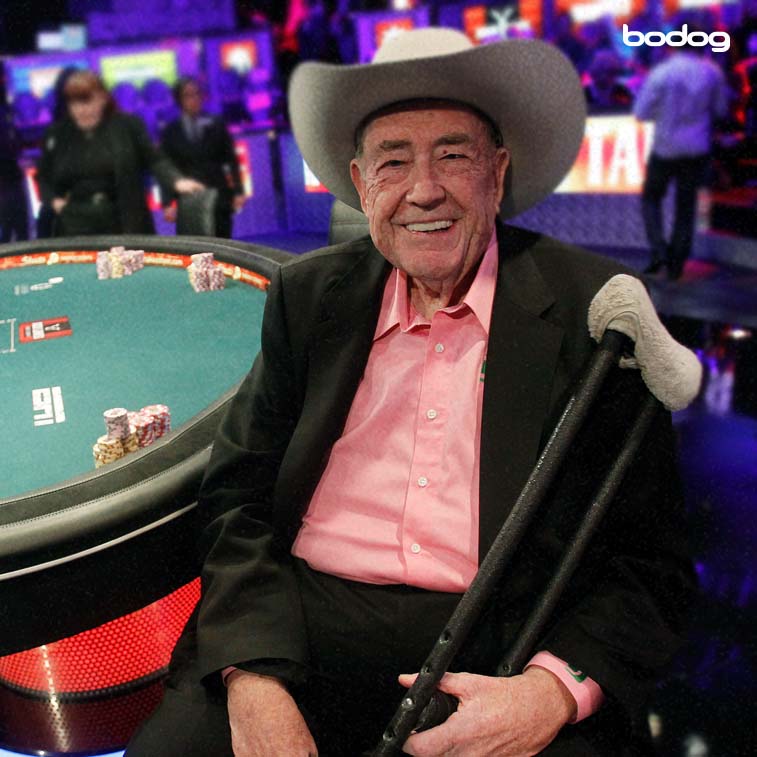 Doyle Brunson posando sorridente para foto junto à mesa de poker