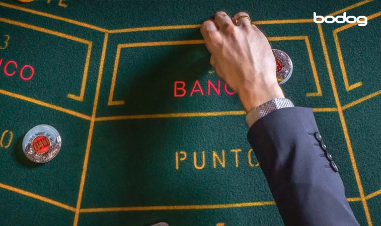 jugador moviendo fichas en mesa de Baccarat