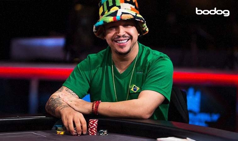 Felipe Mojave sorridente segurando suas fichas em uma mesa de poker