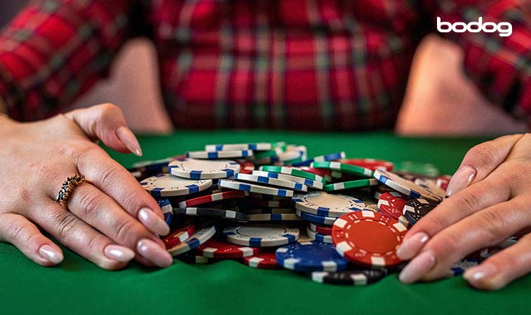 Mulher com um monte de fichas de poker na mesa