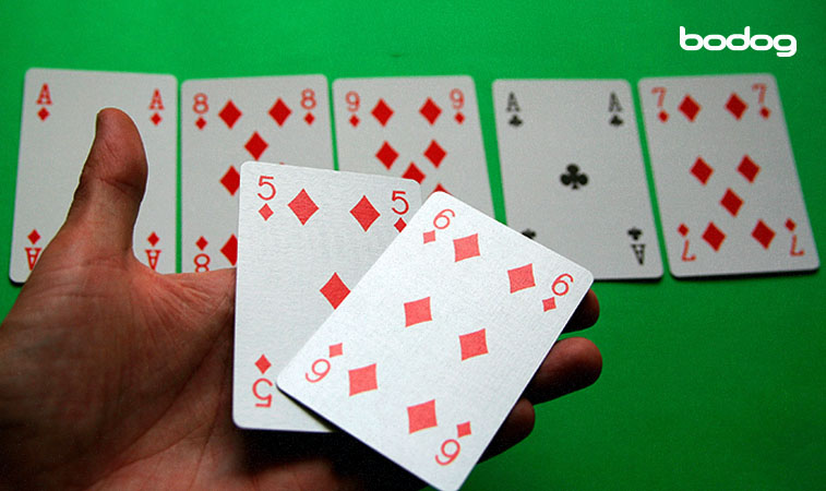 Homem segurando sequência de cartas de baralho