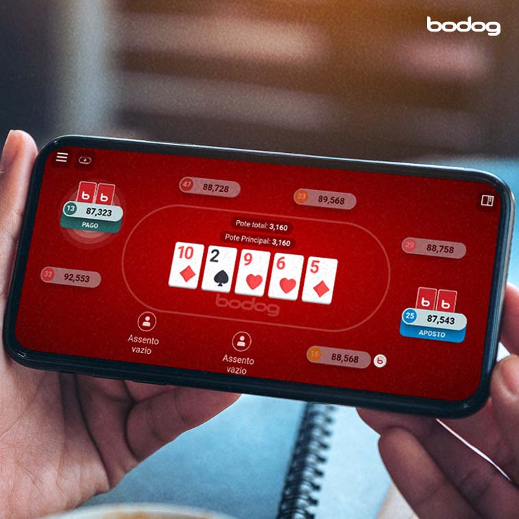 pessoa segurando um celular, enquanto joga em uma mesa de poker online