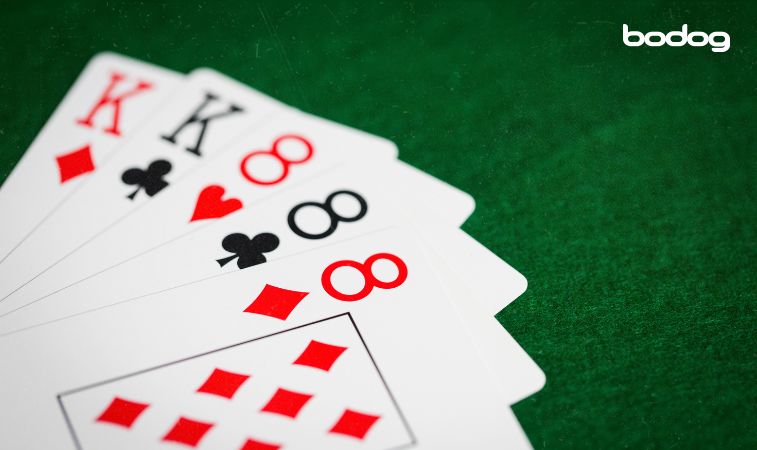 Mão com trio de oitos e dois reis
