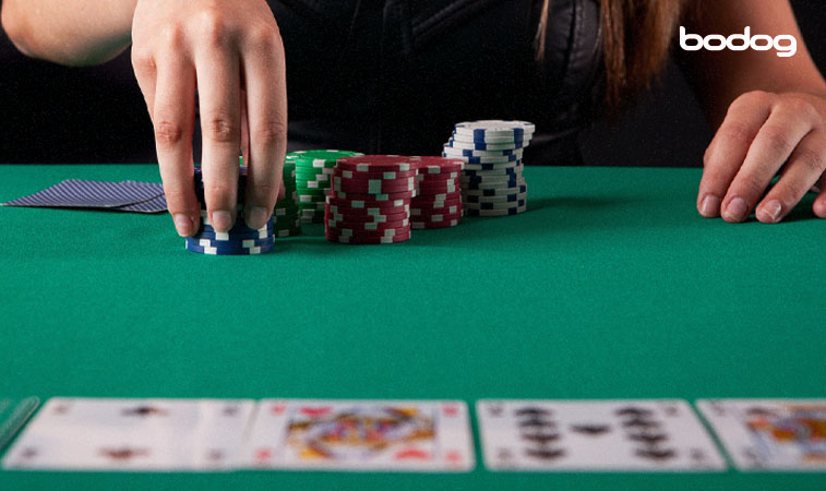 manos colocando fichas en mesa con cartas