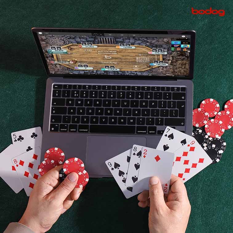 Computadora y manos con cartas y fichas de poker