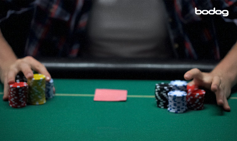 Jugador con fichas en mesa de poker