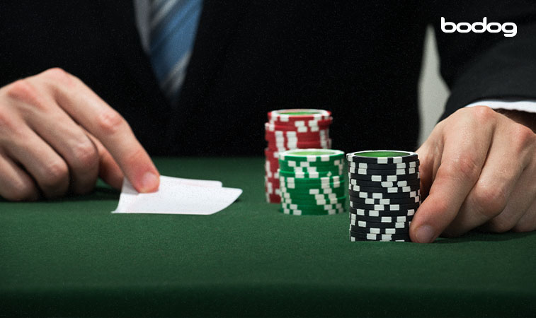 bankroll poker apostas Mãos segurando cartas de poker e fichas