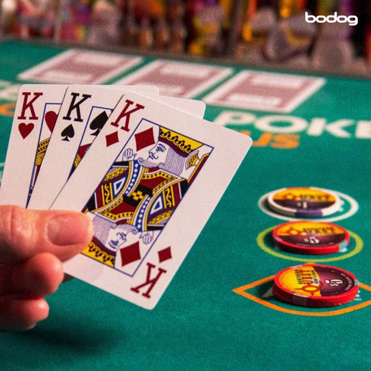 Mano con 3 cartas en mesa de poker
