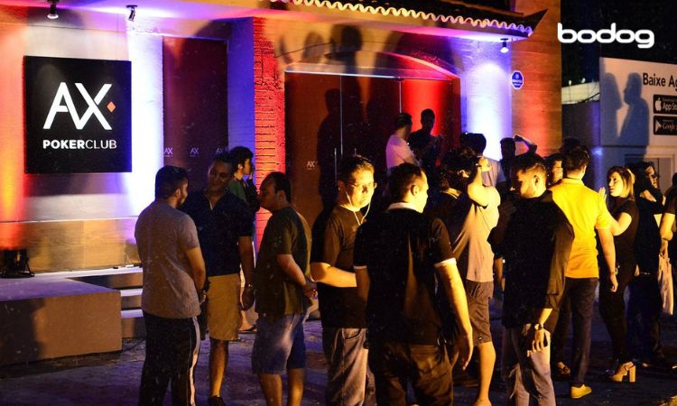 Pessoas interagindo na entrada do AX Poker Club